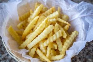 francés papas fritas en un cesta con salsa de tomate foto