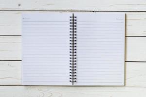 Open notebook with blank pages on wood table photo