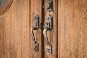 old metal - iron, handle on a wooden door. photo