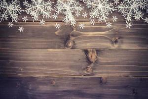 Wooden brown christmas background and white snowflakes with space. photo
