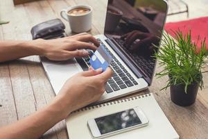 Man holding credit card and using laptop. Online shopping photo