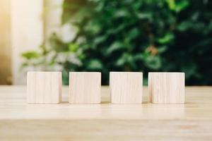 Four wooden toy cubes on wooden table background with copy space photo