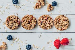 Homemade granola bar and fresh berries on wood table with space. photo