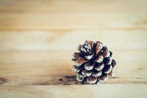 Pine cone on wood table background with space. photo