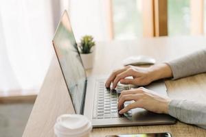 Business woman hand typing laptop computer on wooden table photo