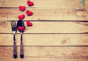 mesa ajuste cuchillería y rojo corazón para cena enamorado día. foto