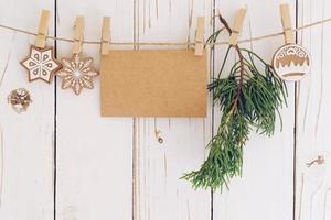 Navidad decoración y blanco papel tarjeta colgando en madera antecedentes. foto