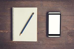 Blank notebook and phone blank screen for advertising on wood table background with space. photo
