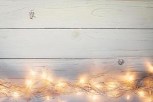 christmas background and lights garland on wood background with space. photo