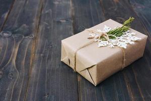 Christmas gift box placed and white snowflakes on wooden planks with space. photo