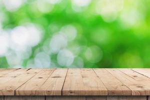 Empty wooden table top and green bokeh display montage for product with space. photo