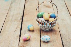 colourful easter egg and basket on wood background photo