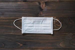 Protective face mask on wood table. photo
