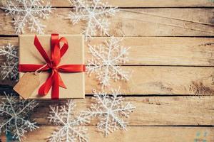 Christmas gift boxes placed and white snowflakes on wooden planks with space. photo