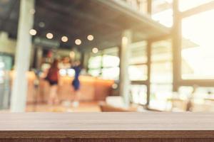 vacío madera mesa y borroso antecedentes cliente a café tienda difuminar antecedentes con Bokeh, Clásico tonificado foto