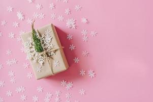 Brown gift box on the pink background with christmas decoration. Minimal styled holiday card with copy space. photo