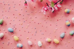 Pastel Easter eggs on pink background top view with natural light. Flat lay style. photo