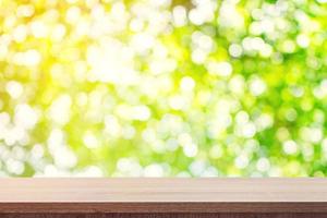 Empty wooden table for product placement or montage and green boken blurred background. photo