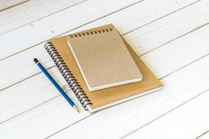 Notebook with blank pages and pencil on wood table photo