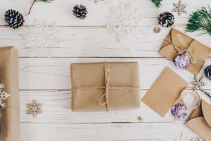 Top view of gift box and christmas card on wooden table with xmas decoration. photo