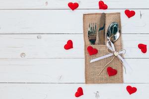 encima madera mesa conjunto cubiertos y rojo corazón para enamorado día con espacio. foto