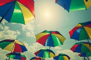 Colorful umbrellas hanging above the street with vintage tone. photo