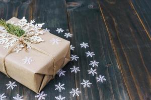 Christmas gift box placed and white snowflakes on wooden planks with space. photo