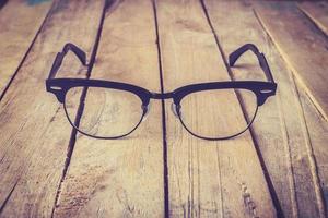 Eyeglasses Glasses with Black Frame Fashion Vintage Style on Wood Desk Background photo