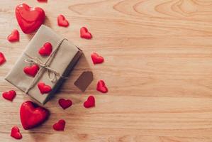 Top view brown gift box and red heart on wood background for valentine day with copy space. photo