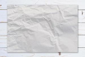 Crumpled paper on wooden paint white background texture with coffee space. photo