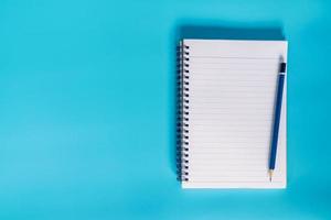 top view notebook paper on blue pastel color background with space. photo
