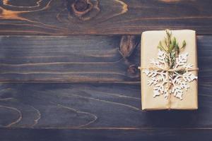 String or twine tied in a bow on kraft paper. Above gift box on wood with space. photo