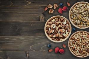 bowl of granola for breakfast with fresh berries, strawberry on wood with copy space. photo