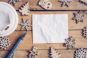 Top view cup coffee and pen, empty paper on wood with christmas decoration for New year concept. photo