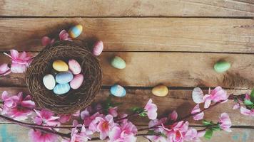 Cherry blossom Artificial flowers and easter egg in nest on vintage wooden background with copy space. photo