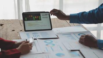 Financial analysts analyze business financial reports on a digital tablet planning investment project during a discussion at a meeting of corporate showing the results of their successful teamwork. video