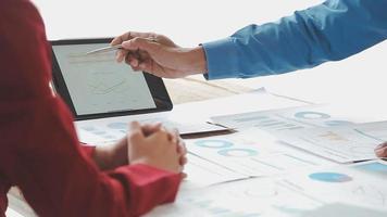 Financial analysts analyze business financial reports on a digital tablet planning investment project during a discussion at a meeting of corporate showing the results of their successful teamwork. video
