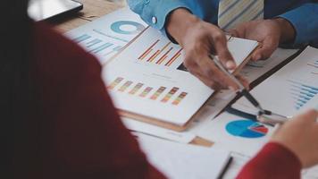 Financial analysts analyze business financial reports on a digital tablet planning investment project during a discussion at a meeting of corporate showing the results of their successful teamwork. video