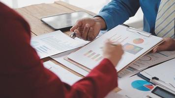 Financial analysts analyze business financial reports on a digital tablet planning investment project during a discussion at a meeting of corporate showing the results of their successful teamwork. video