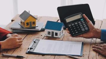 Real estate broker agent presenting and consult to customer to decision making sign insurance form agreement, buy and sell home model, concerning mortgage loan offer for and house insurance video