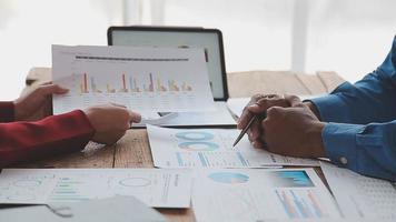 Financial analysts analyze business financial reports on a digital tablet planning investment project during a discussion at a meeting of corporate showing the results of their successful teamwork. video