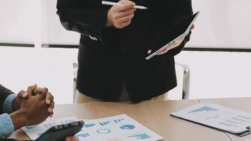 Financial analysts analyze business financial reports on a digital tablet planning investment project during a discussion at a meeting of corporate showing the results of their successful teamwork. video