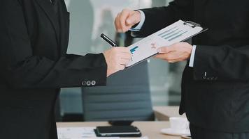 Financial analysts analyze business financial reports on a digital tablet planning investment project during a discussion at a meeting of corporate showing the results of their successful teamwork. video