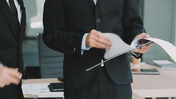 Financial analysts analyze business financial reports on a digital tablet planning investment project during a discussion at a meeting of corporate showing the results of their successful teamwork. video