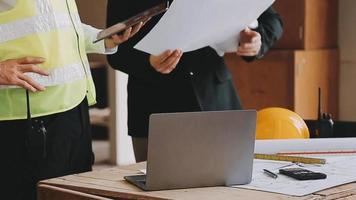 arquitecto hombre trabajando con ordenador portátil y planos, ingeniero inspección en lugar de trabajo para arquitectónico plan, bosquejo un construcción proyecto ,selectivo foco,negocio concepto Clásico color video