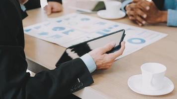 Financial analysts analyze business financial reports on a digital tablet planning investment project during a discussion at a meeting of corporate showing the results of their successful teamwork. video