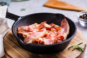 Fried bacon in a pan ready for dinner on the table. photo