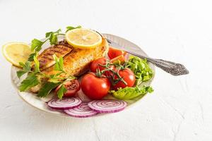 large ceramic plate with grilled chicken fillet breast and fresh vegetables on a white background. delicious food. space for text. menu. photo