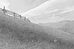 Wooden fence on grassy slope engraving hand drawn sketch photo