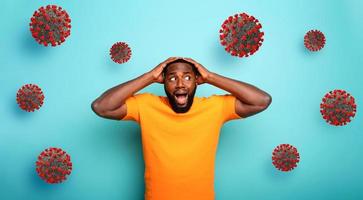 Fearful expression of a boy who is scared to catch the coronavirus. Cyan background. photo